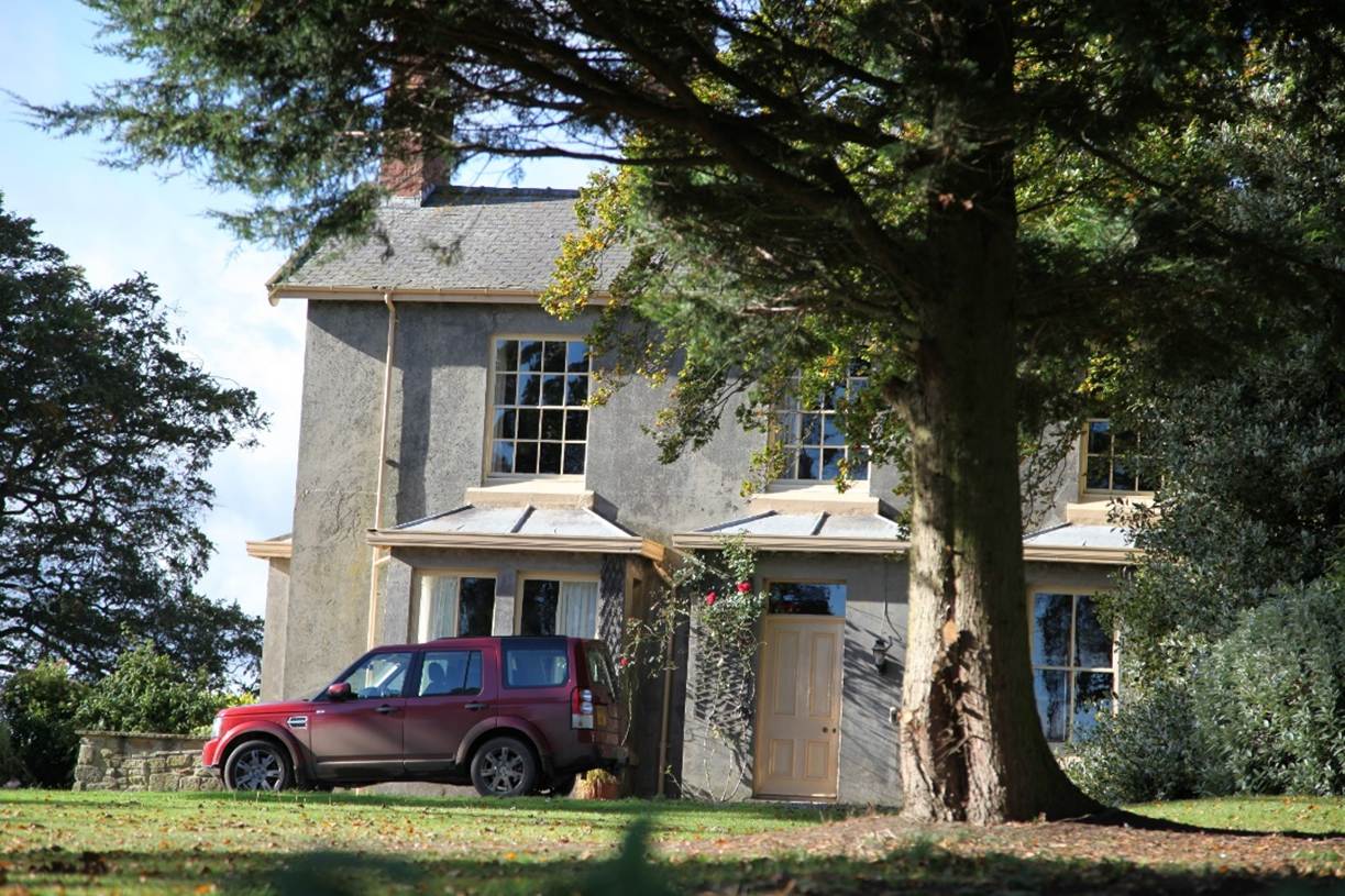 A car parked in front of a house
Description automatically generated